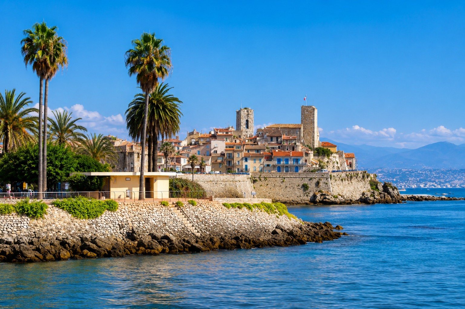 Il Vecchio Antibes e i suoi bastioni sul Mediterraneo — torri saracene, palme e scogli del litorale.