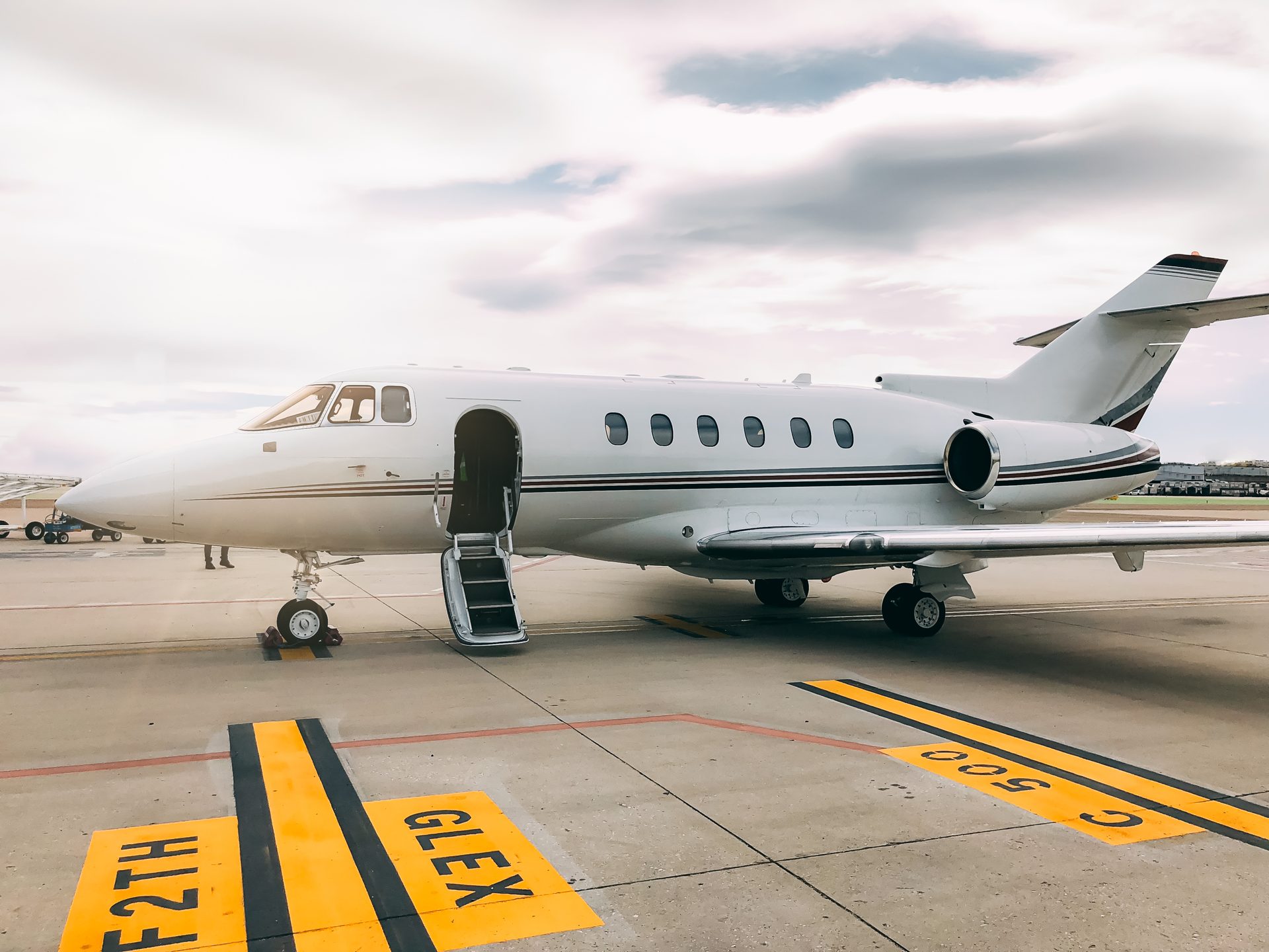 Berline noire de la Maison Vehira sur le tarmac, à proximité d'un jet privé — transfert depuis Nice, Cannes-Mandelieu ou La Môle.